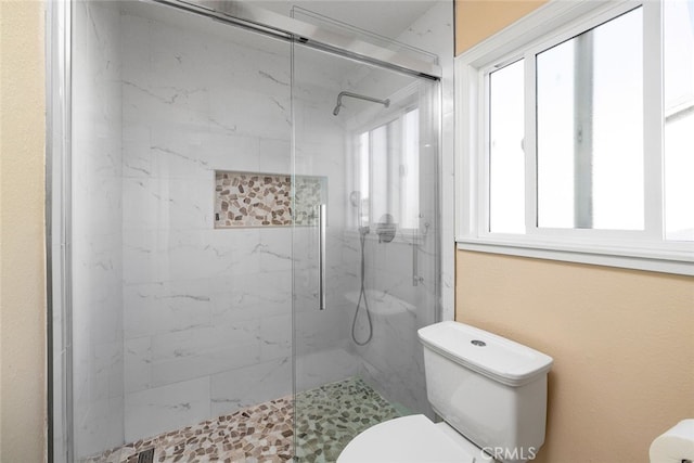 bathroom featuring an enclosed shower and toilet