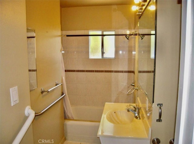 bathroom featuring shower / bath combo with shower curtain and sink