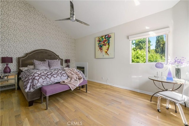 bedroom with ceiling fan, lofted ceiling, and hardwood / wood-style flooring