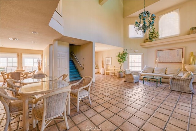 tiled dining space featuring a towering ceiling