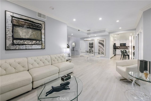 living room with light hardwood / wood-style flooring and crown molding