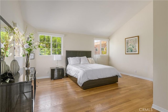 bedroom with light hardwood / wood-style flooring and lofted ceiling