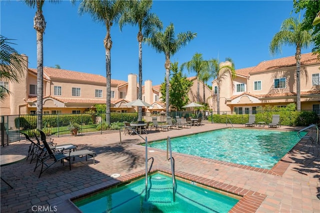 view of swimming pool featuring a patio area and a community hot tub