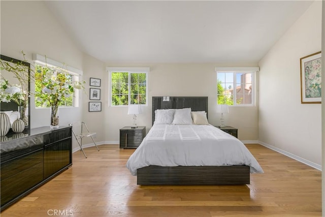 bedroom with light hardwood / wood-style floors and vaulted ceiling