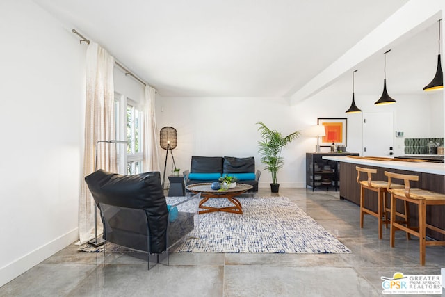 living room featuring beam ceiling and concrete flooring