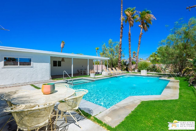 view of pool with a patio area and a lawn