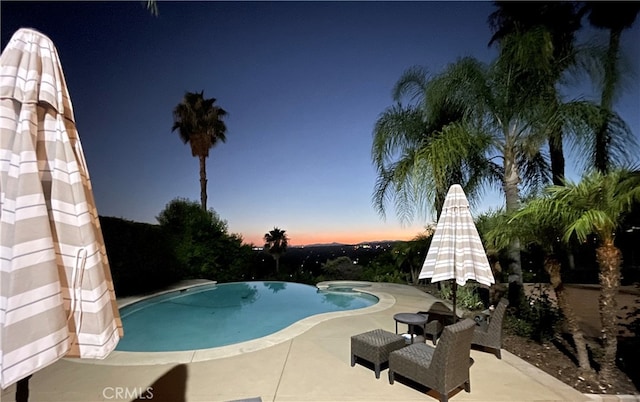 pool at dusk with a patio