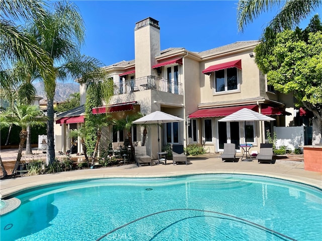 back of property with a patio area and a balcony