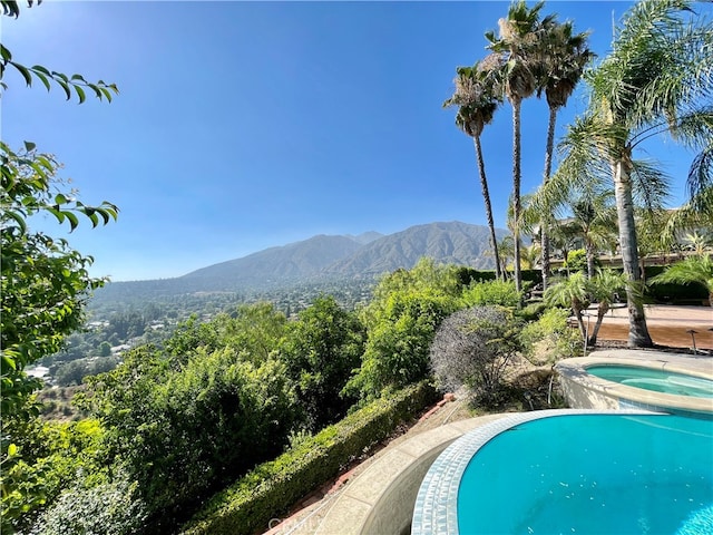 view of pool featuring a mountain view and an in ground hot tub