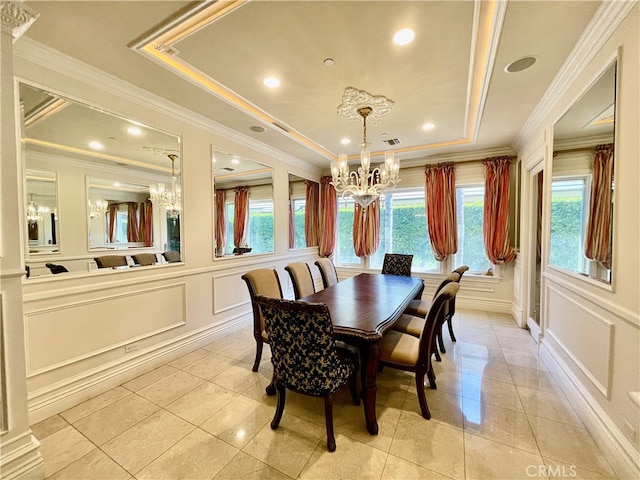 tiled dining space with crown molding and a tray ceiling