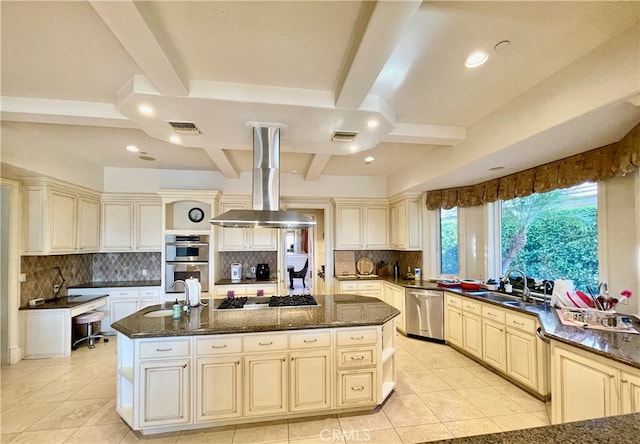 kitchen with cream cabinets, island exhaust hood, a center island, stainless steel appliances, and beam ceiling