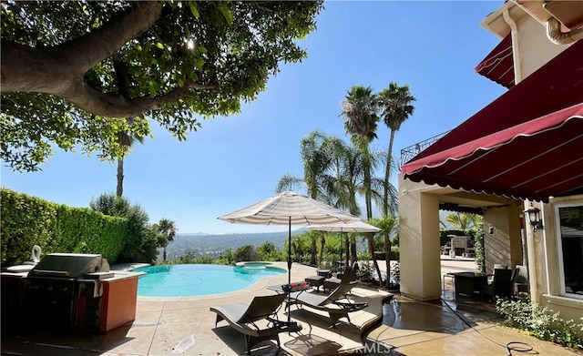 view of pool with a patio and grilling area