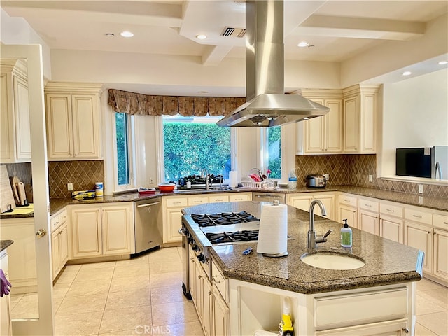 kitchen featuring sink, an island with sink, stainless steel appliances, and cream cabinets