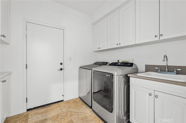 clothes washing area with cabinets, washer and clothes dryer, and sink