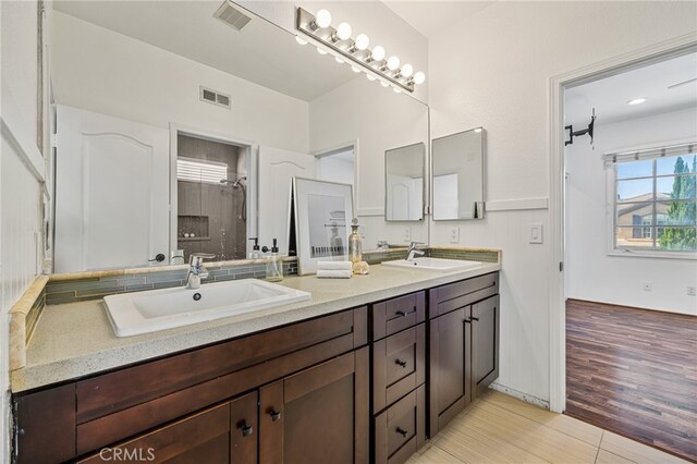 bathroom with vanity, a shower, and hardwood / wood-style flooring