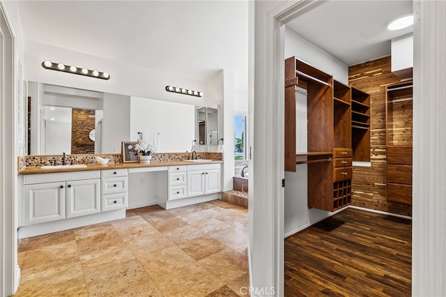 bathroom featuring wooden walls, hardwood / wood-style flooring, and vanity