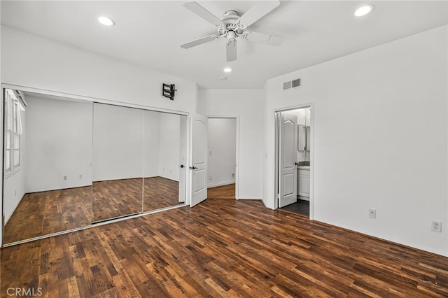 unfurnished bedroom with ceiling fan, a closet, ensuite bath, and dark hardwood / wood-style flooring