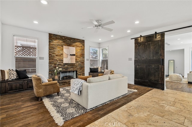 living room with plenty of natural light, dark hardwood / wood-style floors, a fireplace, and a barn door