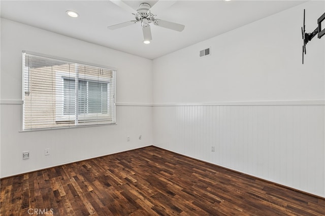 unfurnished room with wood walls, ceiling fan, and dark hardwood / wood-style floors