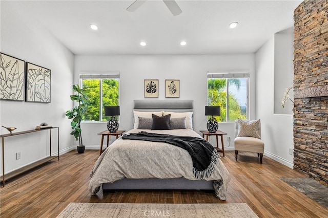 bedroom with ceiling fan, hardwood / wood-style floors, and multiple windows