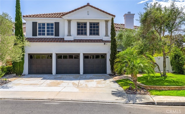 mediterranean / spanish house with a garage and a front lawn