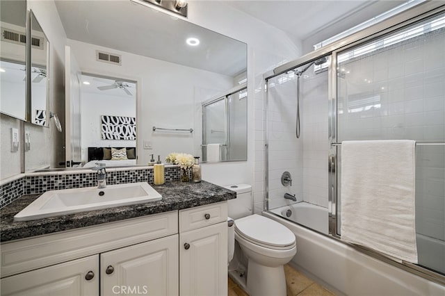 full bathroom featuring ceiling fan, shower / bath combination with glass door, vanity, toilet, and tile patterned flooring