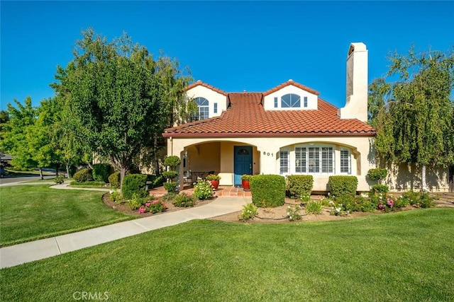 mediterranean / spanish home with a porch and a front yard