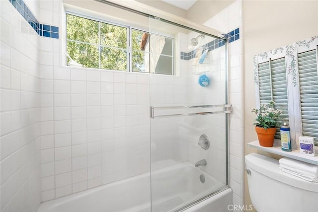 bathroom with shower / bath combination with glass door and toilet