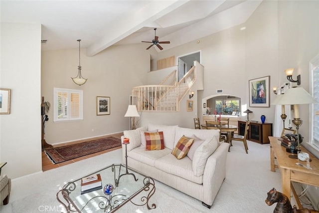 carpeted living room featuring ceiling fan, beam ceiling, and high vaulted ceiling