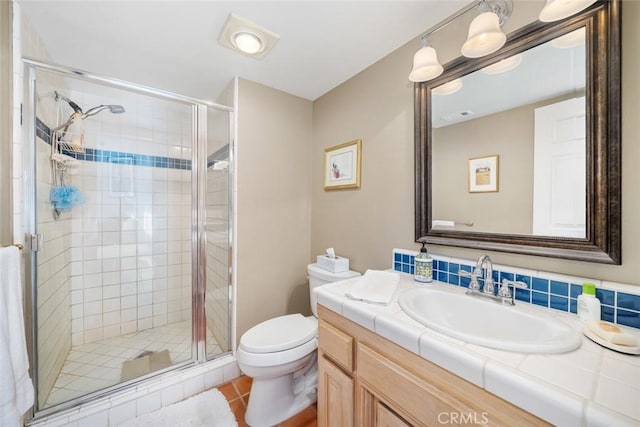 bathroom with vanity, a shower with door, backsplash, tile patterned flooring, and toilet