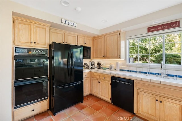 kitchen featuring black appliances, sink, light brown cabinetry, and tile countertops