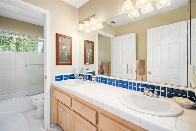 full bathroom featuring tile patterned flooring, backsplash, bath / shower combo with glass door, toilet, and vanity