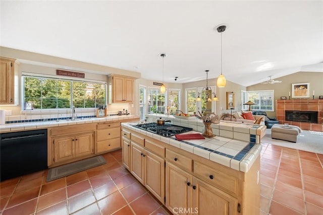 kitchen with black dishwasher, gas stovetop, plenty of natural light, and tile counters