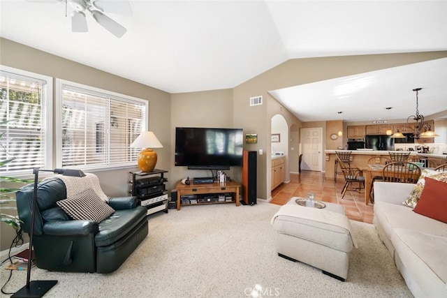 living room featuring ceiling fan, light tile patterned flooring, and vaulted ceiling