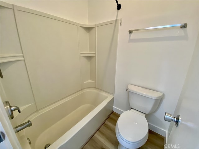 bathroom with shower / bathing tub combination, hardwood / wood-style flooring, and toilet