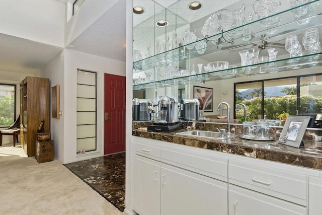 kitchen featuring a wealth of natural light, sink, and white cabinets