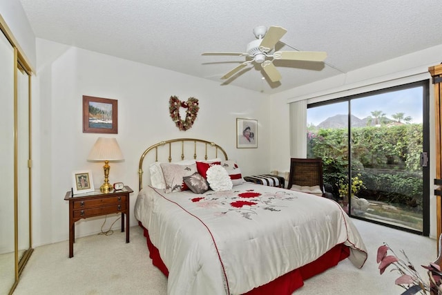 bedroom featuring ceiling fan, access to outside, a closet, and a textured ceiling