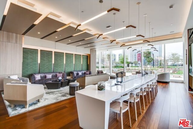 kitchen with a spacious island, dark wood-type flooring, a kitchen breakfast bar, and decorative light fixtures