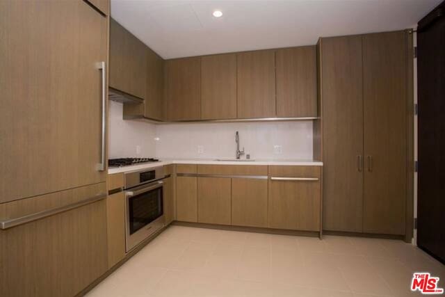 kitchen featuring sink, stainless steel appliances, and range hood