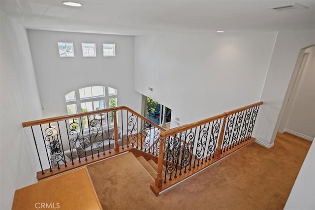 stairway featuring carpet and a towering ceiling