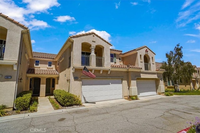 mediterranean / spanish house featuring a garage and a balcony