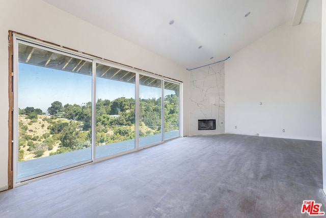 unfurnished living room with vaulted ceiling with beams and a premium fireplace