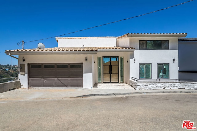 mediterranean / spanish home featuring a garage