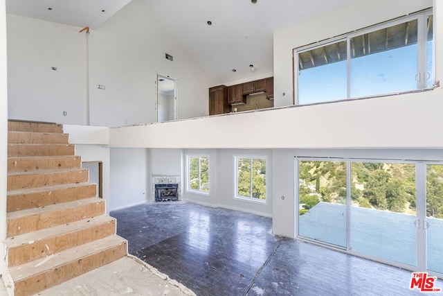 unfurnished living room featuring high vaulted ceiling and hardwood / wood-style floors