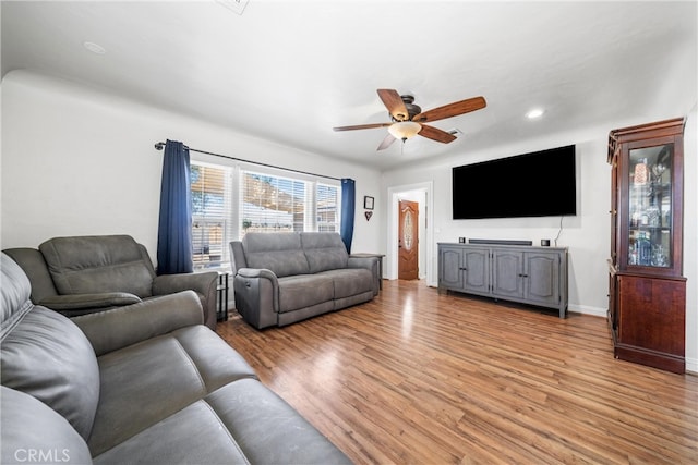 living room with ceiling fan and light hardwood / wood-style flooring