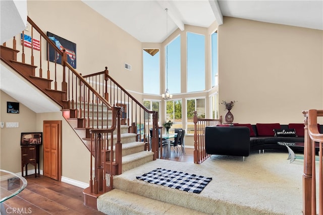 stairway with a notable chandelier, wood-type flooring, beam ceiling, and high vaulted ceiling