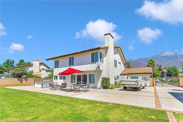 back of property featuring a patio, a lawn, and a mountain view