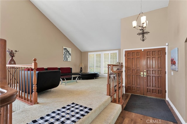 foyer entrance with wood-type flooring, a notable chandelier, and high vaulted ceiling