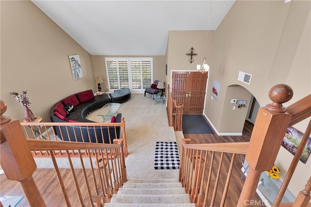 living room featuring an inviting chandelier, carpet, and high vaulted ceiling