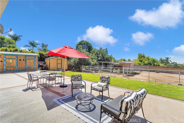 view of patio featuring a shed and an outdoor fire pit